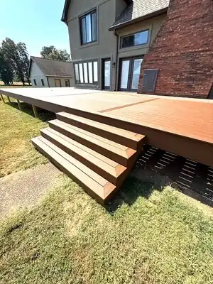 New brown wooden deck with stairs at back of gray and brick house in Murray KY