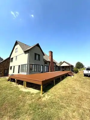 Completed backyard deck extension attached to a modern Kentucky home with brick chimney