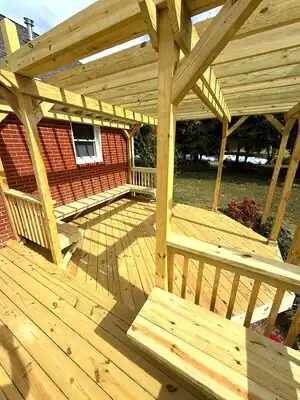 New wooden deck with benches and partial pergola attached to brick house in Murray KY