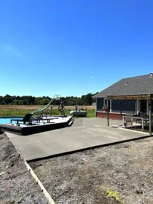 Patio and pool area beside a house with a covered porch in a rural Kentucky backyard
