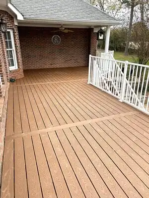 Completed brown deck with white railing attached to brick house in Kentucky under a covered porch